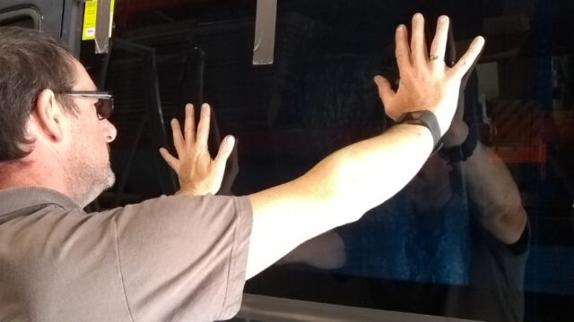 A skilled technician completing a campervan window fitting job.